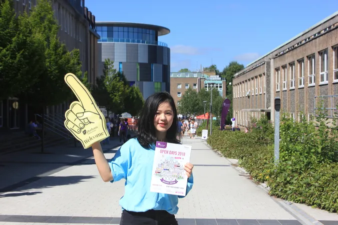 Student holding a Durham brochure and foam finger